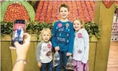  ?? ?? Lithia resident Erin Bratspis takes a photo of her children Jackson, 8, Laila, 6, and Landon, 4, at the 2020 Florida Strawberry Festival.