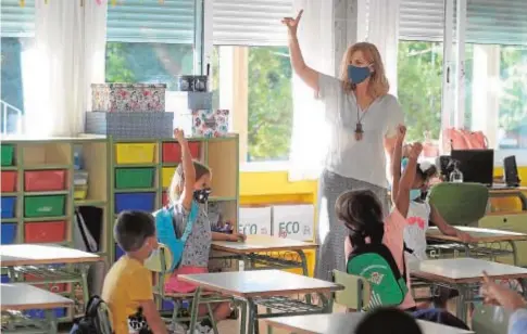  ?? AFP ?? Una profesora dando clases con mascarilla­s en un colegio sevillano