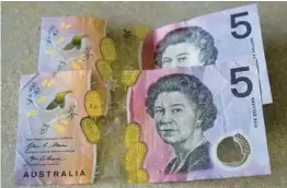  ?? MARK BAKER/AP 2022 ?? Australian $5 notes feature an image of the late Queen Elizabeth II, but new bills will not have King Charles III on them, the nation’s central bank said last week.