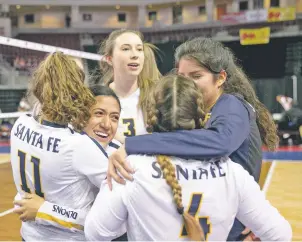  ?? PHOTOS BY MELANIE METZ/FOR THE NEW MEXICAN ?? Santa Fe High senior defensive specialist Taliyah Balladares hugs sophomore Ivy St. Clair, left, while Tanisha Ortiz, front hugs Alyssa Sandoval after beating Hobbs, 23-25, 23-25, 25-17, 25-21, 15-11, in the first round of the Class 5A State Volleyball Tournament on Thursday in the Santa Ana Star Center.