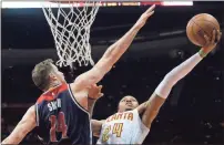  ?? John Bazemore / The Associated Press ?? Atlanta’s Kent Bazemore (right) goes up against Washington’s Jason Smith during the first half of Game 6 on Friday.