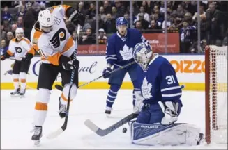  ?? CHRIS YOUNG, THE CANADIAN PRESS ?? Philadelph­ia’s Wayne Simmonds, left, tries to knock the puck past Maple Leafs goalie Frederik Andersen in first-period National Hockey League action in Toronto on Thursday night. The Leafs won, 4-2.