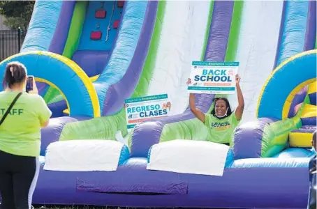  ?? VASHON JORDAN JR./CHICAGO TRIBUNE ?? Kyrah Davis glides down an inflatable slide during a CPS Back to School Bash at Michele Clark High School in the Austin neighborho­od on Aug. 13.