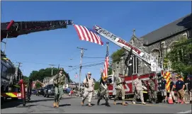  ?? BILL UHRICH — MEDIANEWS GROUP ?? The honor guard marches beneath a flag hoisted by the West Reading and Adamstown fire companies at the start of the 2022Mohnto­n Memorial Day parade. Officials are looking to increase participat­ion in this year’s parade.