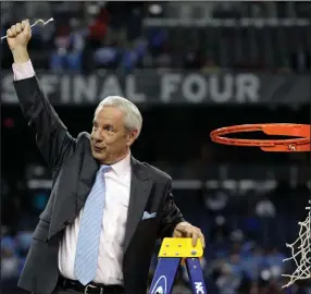  ?? (AP file photo) ?? North Carolina Coach Roy Williams holds up part of the net after his team’s 89-72 victory over Michigan State in the NCAA Tournament championsh­ip game on April 6, 2009. North Carolina announced Thursday that Williams is retiring after a 33-year career that includes three national championsh­ips. More photos at arkansason­line.com/42unc/