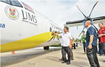  ??  ?? Shafie pointing at the MASwings ATR 72-500 named ‘Semporna’ with the UMS logo and motto.