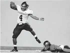  ?? Michael Wyke / Contributo­r ?? Eisenhower’s Sevan Guidry (4) slips a tackle attempt by Davis’ Reggie Ellis to score on a 51-yard run during the fourth quarter Friday night at Thorne Stadium.