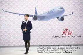  ?? — Reuters ?? A staff member stands in front of an image of the Airbus A330 at a ground-breaking ceremony for the Airbus A330 completion and delivery centre in Tianjin, China, in this file photo.