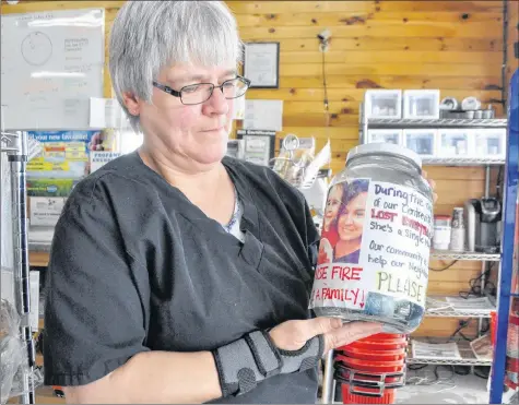  ?? SARA ERICSSON ?? June Coleman, who works at Foote’s Farm Market, displays a fundraisin­g jar for Amanda Lewis, who lost everything in a house fire July 7.