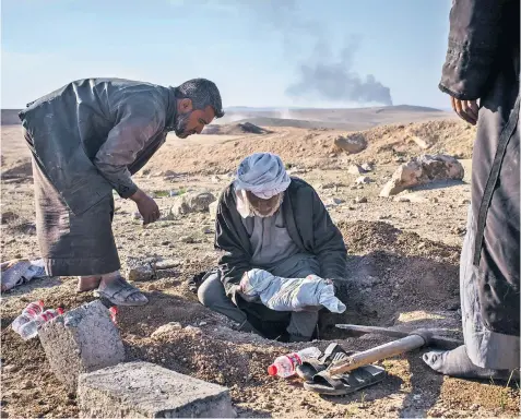  ??  ?? Two-month-old Hajar Mohamed is laid to rest in the desert by her family as fighting rages in the distance