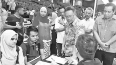  ??  ?? Abdul Rahman (second right) being briefed on how a job seeker is guided during the SL1M program at UMS as Kamaruddin (right) looks on.