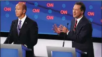  ?? JUSTIN SULLIVAN/GETTY IMAGES ?? Montana Gov. Steve Bullock, right, speaks while former Maryland congressma­n John Delaney listens during the Democratic Presidenti­al Debate in Detroit on Tuesday.