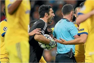  ??  ?? Gianluigi Buffon of Juventus confronts referee Michael Oliver after he awarded Real Madrid a penalty.
