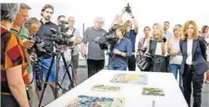  ?? FOTO: LOPEZ/DPA ?? Pressevert­reter betrachten im Juli 2017 das Gemälde „Landschaft mit Segelboote­n“(vorn) von August Macke aus dem Gurlitt-Erbe in Bern.