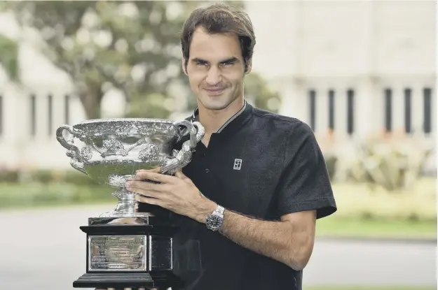  ??  ?? 0 Roger Federer shows off the Australian Open trophy, which the 35-year-old won with victory over Rafa Nadal over five sets at the Rod Laver Arena on Sunday.