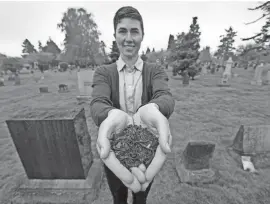  ?? ELAINE THOMPSON/AP ?? Katrina Spade, the founder and CEO of Recompose, displays a sample of the compost material left from the decomposit­ion of a cow, using a combinatio­n of wood chips, alfalfa and straw, as she poses in a cemetery in Seattle on April 19, 2019.