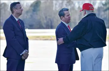  ?? HYOSUB SHIN / HYOSUB.SHIN@AJC.COM ?? U.S. Rep. Doug Collins (left), R-Ga., and Gov. Brian Kemp greet President Donald Trump on Friday at Dobbins Air Reserve Base after Trump’s trip to twister-hit Tennessee. Trump visited the CDC after first canceling.