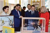  ?? Ludovic Marin/Associated Press ?? China’s President Xi Jinping, second from left, presents gifts to French President Emmanuel Macron, while China’s first lady Peng Liyuan, left, and Brigitte Macron, right, look on.