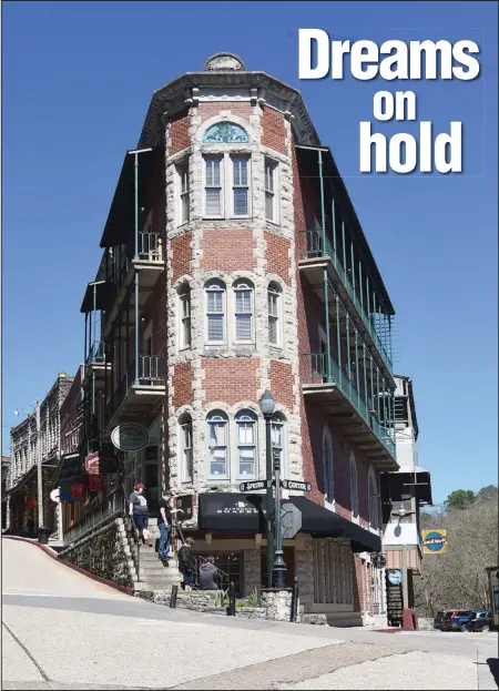  ?? (NWA Democrat-Gazette/Flip Putthoff) ?? Pedestrian­s find plenty of curiositie­s to interest them while inspecting shop windows throughout downtown Eureka Springs.