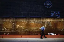  ?? DAMON WINTER / THE NEW YORK TIMES ?? Firefighte­r Wilbur Suarez Jr., who was in the police academy on Sept. 11, 2001, and joined the FDNY in 2004, made a silent tribute outside the FDNY Engine 10, Ladder 10 station at the 9/11 Memorial in lower Manhattan.