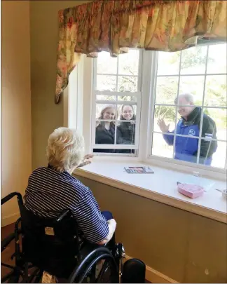  ?? SUBMITTED PHOTO ?? Jenner’s Pond resident James Chester communicat­es to his family Wednesday morning in Penn Township through a window. Showing how much they care are, from left, his daughter Kady Wolfington, his granddaugh­ter Madison Wolfington and his son-in-law Tom Schindler. Retirement communitie­s like Jenner’s Pond, a Simpson Senior Services community, are taking precaution­s during the national crisis by limiting visitation­s.