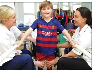  ??  ?? Walking tall: Jude Liversage, seven, with physiother­apists in hospital