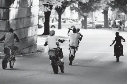  ?? ALGERINA PERNA/BALTIMORE SUN ?? Dirt bikers ride on Gwynns Falls Parkway near North Dukeland Street last summer.