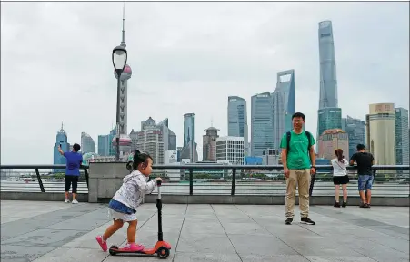  ?? YIN LIQIN / CHINA NEWS SERVICE ?? Tourists and locals enjoy at the Bund area of Shanghai.