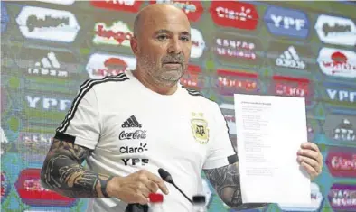  ?? REUTERS / AGUSTÍN MARCARIAN ?? Sampaoli muestra la lista de convocados a los medios de comunicaci­ón.