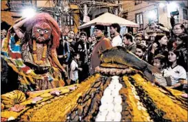  ?? PRAKASH MATHEMA/GETTY-AFP ?? A dancer wearing a traditiona­l mask receives offerings Thursday on the seventh day of the Indra Jatra Festival in Kathmandu, Nepal. The eight-day Hindu observance celebrates Indra, the king of the gods as well as the god of rain.