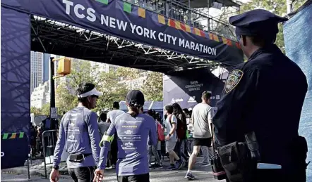  ?? Richard Drew/Associated Press ?? Policial monitora o local da faixa de chegada da maratona de Nova York; efetivo foi redobrado para o evento esportivo