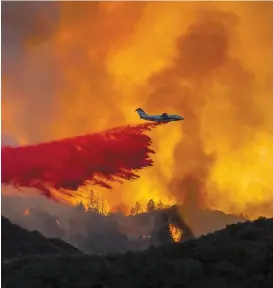  ?? PHOTO AFP ?? Un avion-citerne tente de maîtriser l’incendie Holy, situé près des Comtés d’orange et de Riverside.