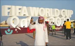  ?? AP PHOTO/HASSAN AMMAR ?? A man takes a selfie in front of a sign reading in English “Fifa World Cup, Qatar 2022” at the corniche in Doha, Qatar, Nov. 11. Final preparatio­ns are being made for the soccer World Cup which starts on Nov. 20 when Qatar face Ecuador.