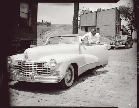  ?? © Charles “Teenie” Harris Archive, Carnegie Museum of Art photos ?? Bandleader and musician Billy Eckstine with a Cadillac convertibl­e on a street in a residentia­l neighborho­od, June 1947.