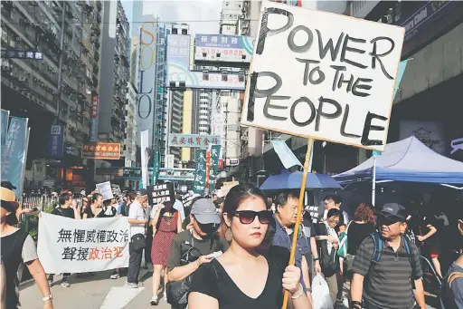  ?? — Gambar Reuters ?? BANGKIT LANTANG: Aktivis prodemokra­si mengadakan perarakan protes sempena sambutan hari kebangsaan China di Hong Kong, semalam.