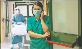  ??  ?? Teti talks on the phone in the sub-intensive covid-19 unit of the hospital. When she’s not visiting patients, Teti is constantly on the phone with other department­s because on this Saturday she was the only infectious diseases specialist in the hospital.