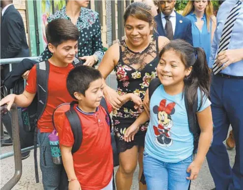  ?? MARCUS SANTOS / DAILY NEWS ?? Yeni Gonzalez and her children Lester, 11, Deyuin, 6, and Jamelin, 9, celebrate outside of the Cayuga Centers after being reunited on Friday.