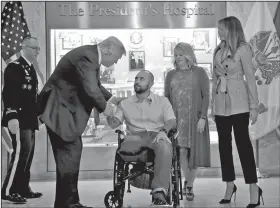  ?? AP/ALEX BRANDON ?? President Donald Trump shakes hands Saturday with U.S. Army Sgt. First Class Alvaro Barrientos after awarding him with a Purple Heart as first lady Melania Trump (right) stands with Tammy Barrientos (second from right) at Walter Reed National Military...