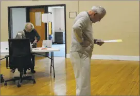  ??  ?? Art McCormack studies the ballot before voting on the $31.6 million Bethel town budget at the Clifford J. Hurgin Municipal Center on Tuesday. It passed.