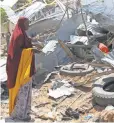  ?? SAID YUSUF WARSAME, EPA ?? A woman looks over rubble from a May 17 explosion in Mogadishu, Somalia.