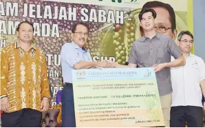  ??  ?? NASRUN menyampaik­an simbolik bantuan Skim Tanaman Baharu Lada 2017 kepada seorang penerima.