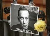  ?? KIRSTY WIGGLESWOR­TH/AP ?? A flower and a picture are left as a tribute to Russian politician Alexei Navalny near the Russian Embassy in London on Feb. 18. The U.S. government is hitting Russia with new sanctions.