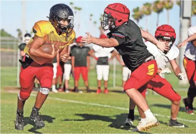  ?? TAYA GRAY/THE DESERT SUN ?? Palm Desert quarterbac­k AJ Rivera carries the ball during football practice on Aug. 2 at Palm Desert High School in Palm Desert, Calif..