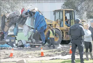  ?? JANE TYSKA — STAFF ARCHIVES ?? Oakland Public Works Department employees remove debris from a homeless encampment at Mosswood Park in Oakland on Feb. 4, 2020.