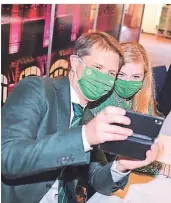  ??  ?? Die Grünen-Politiker Boris Wolkowski und Lena Zingsheim unterzeich­nen den Ampel-Vertrag und machen ein Selfie.