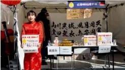  ?? 新华社供图 ?? 2月8日，在日本东京池袋，“旗袍女孩”在“东京灯会满月祭”现场为中国募捐。