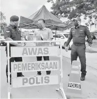  ??  ?? SUMBANGAN: Sadan (tengah) diiringi Hamizi (kanan) menyampaik­an bantuan makan kepada petugas SJR di Jalan Maktab KENT Tuaran.