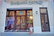  ?? AP PHOTO BY CARLOS GIUSTI ?? In this Friday, Oct. 20, 2017 photo, a man sits outside Casa Blanca Hotel, one of the few hotels still open one month after the passage of Hurricane Maria, on Fortaleza Street in Old San Juan, Puerto Rico. About a third of the hotels in Puerto Rico...