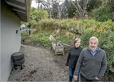  ?? JOHN KIRKANDERS­ON/STUFF ?? Sue and Michael Denny, who are frustrated at the consenting costs for a retaining wall they need behind the garage at their property in Governors Bay, Banks Peninsula.