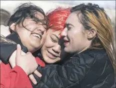  ?? Haley Nelson/Post-Gazette ?? Carnegie Mellon University art majors, from left, Maya Zane Kaisth, Clair Chin and Levitt Summer embrace Wednesday at the CMU Internatio­nal Women's Day walkout at the university in Oakland.